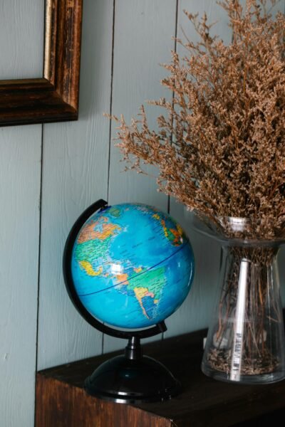 globe décoratif bleu posé sur un meuble, décoration intérieure avec bouquet sec, globe terrestre pour salon ou bureau